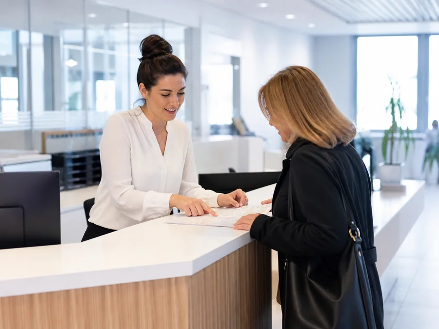 Une agente d’accueil accompagne une usagère dans un service public.